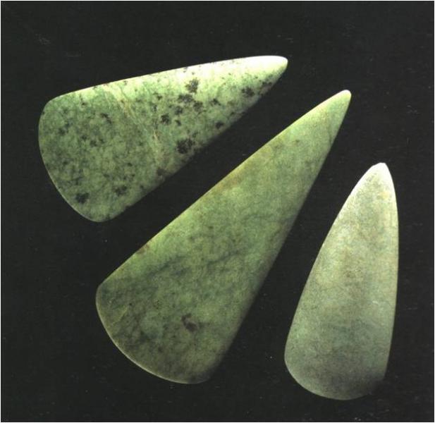 A photograph showing three axeheads of green coloured marbled alpine rock