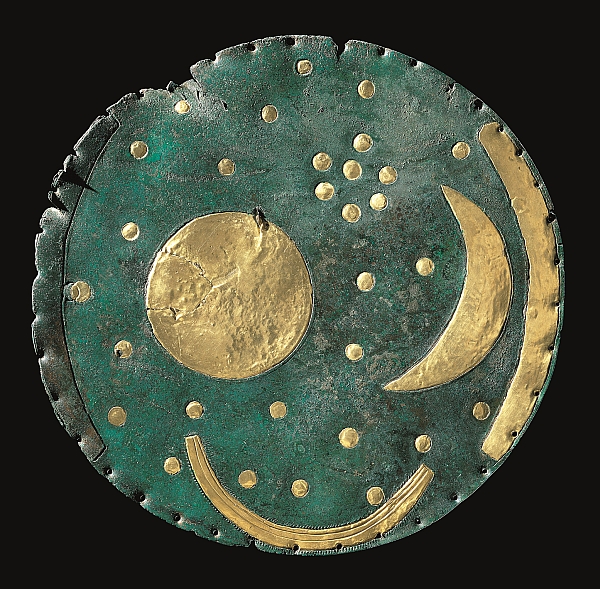 A photograph of a circular disc of bronze decorated with sheet-gold depictions of a crescent moon, stars and the sun or full moon