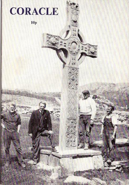 Black and white front colour photo with four men stood around a large replica stone cross in a graveyard