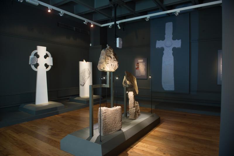 A display of stone fragments and interpretation boards within a museum gallery