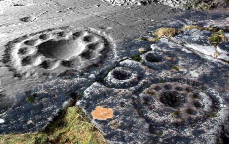 A computer generated colour image of cup and ring marks on a stone combining different techniques to highlight the features.