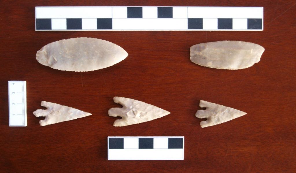 Two flint scrapers and three barbed and tanged arrowheads.