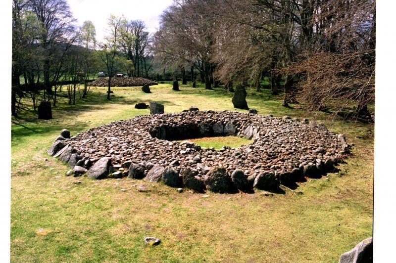 Ring cairn in the foreground with standing stones and a further cairn in the background.
