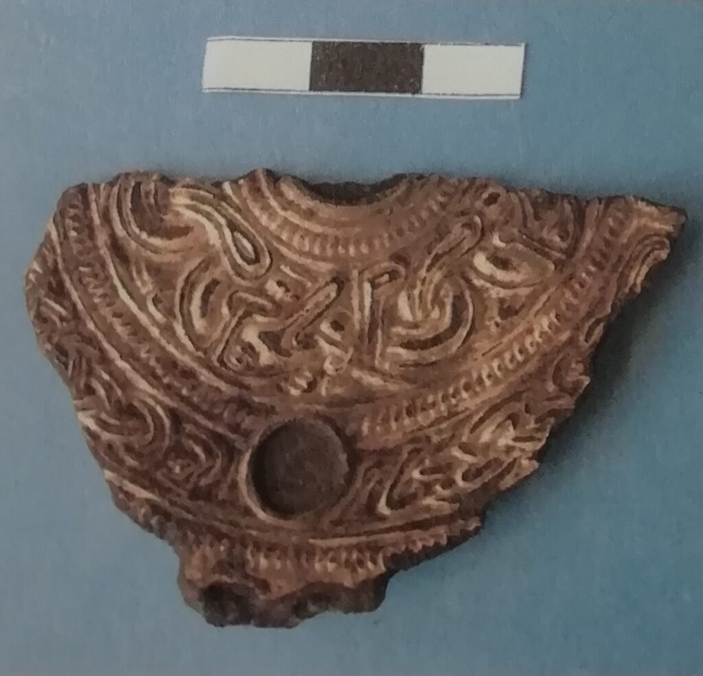 Fragment of gilded disc mount with different styles of decoration used and an empty inset. 