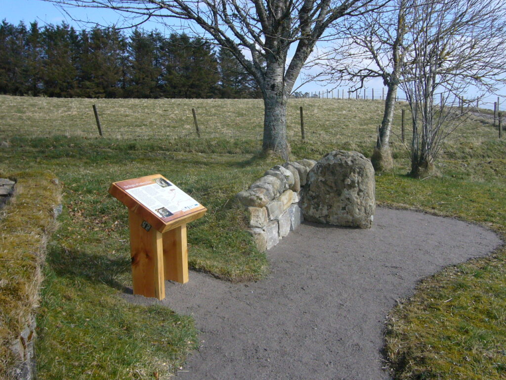 Path leading to information panel and decorated stone.