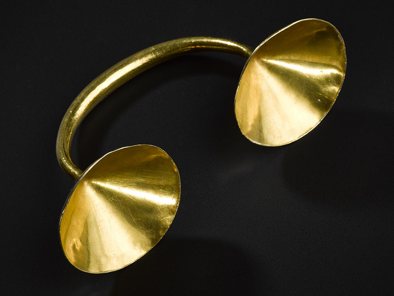 Gold object consisting of a bent band with cup shaped terminals