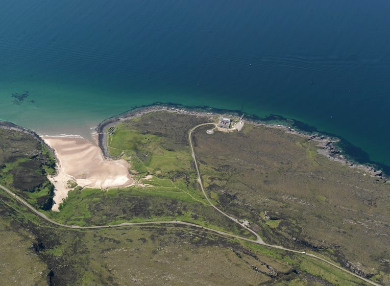 Aerial picture of coastal site within the context of green blue water and the land surrounding it.
