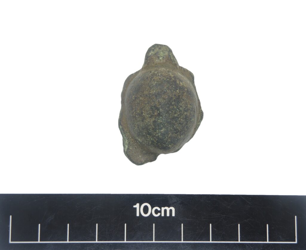 An irregularly shaped 'knob' of bronze taken against a white background. It is brown with yellow specks and is largely round or spherical, with an irregular base. 
