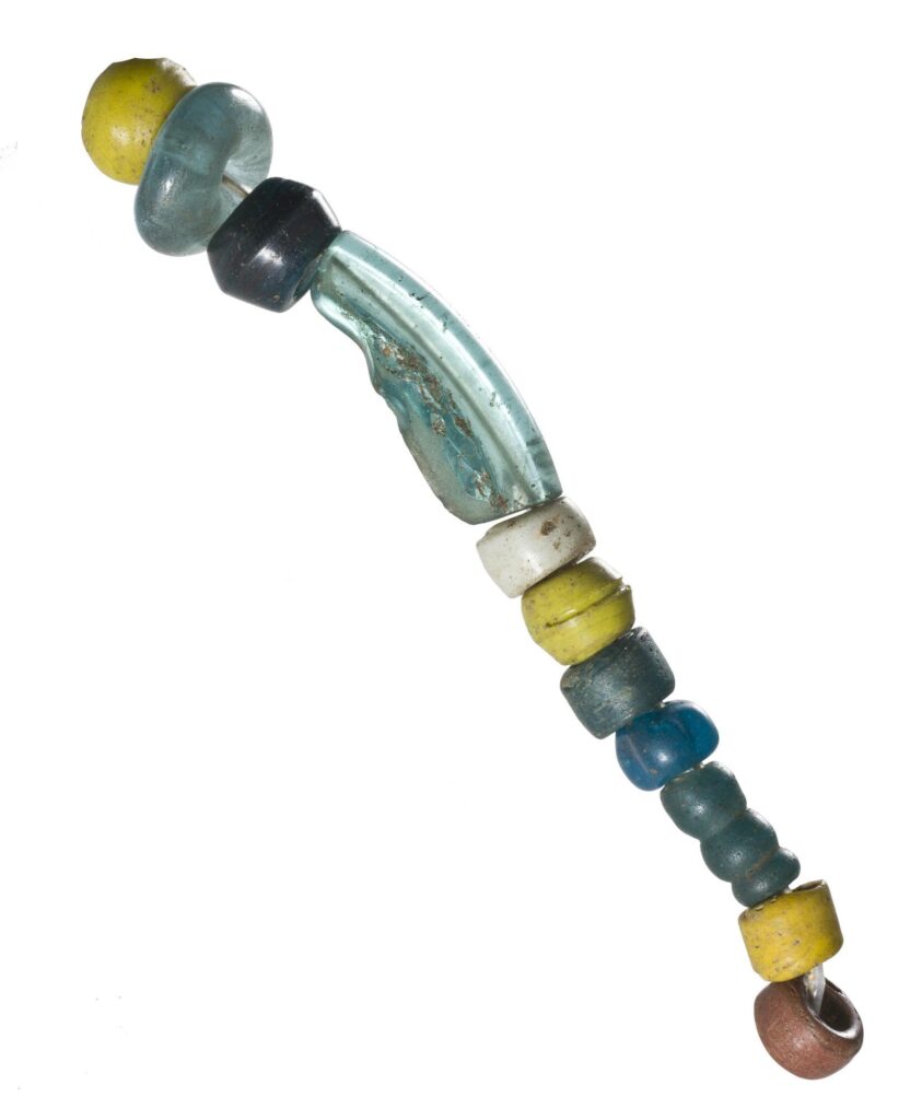 Close-up photograph of a necklace made of glass beads in yellow, blue, black and brown.