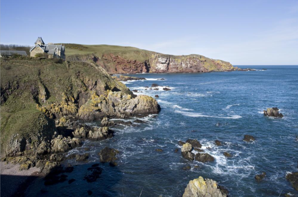 Photograph of the cliffs at St Abbs. There is a house on the cliffs to the right hand side.