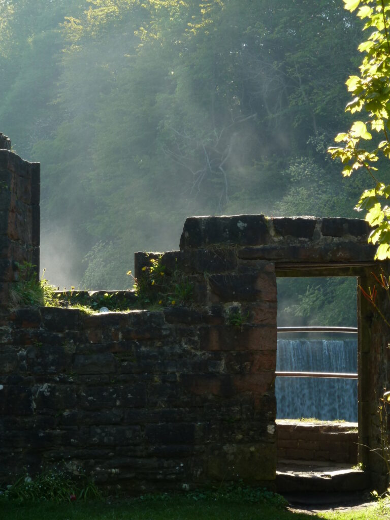 Photograph in colour of mills with waterfall behind