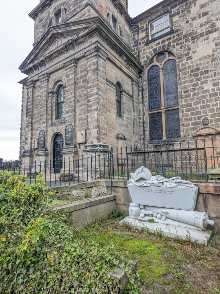 photograph of the tomb, in white, in front of the kirk