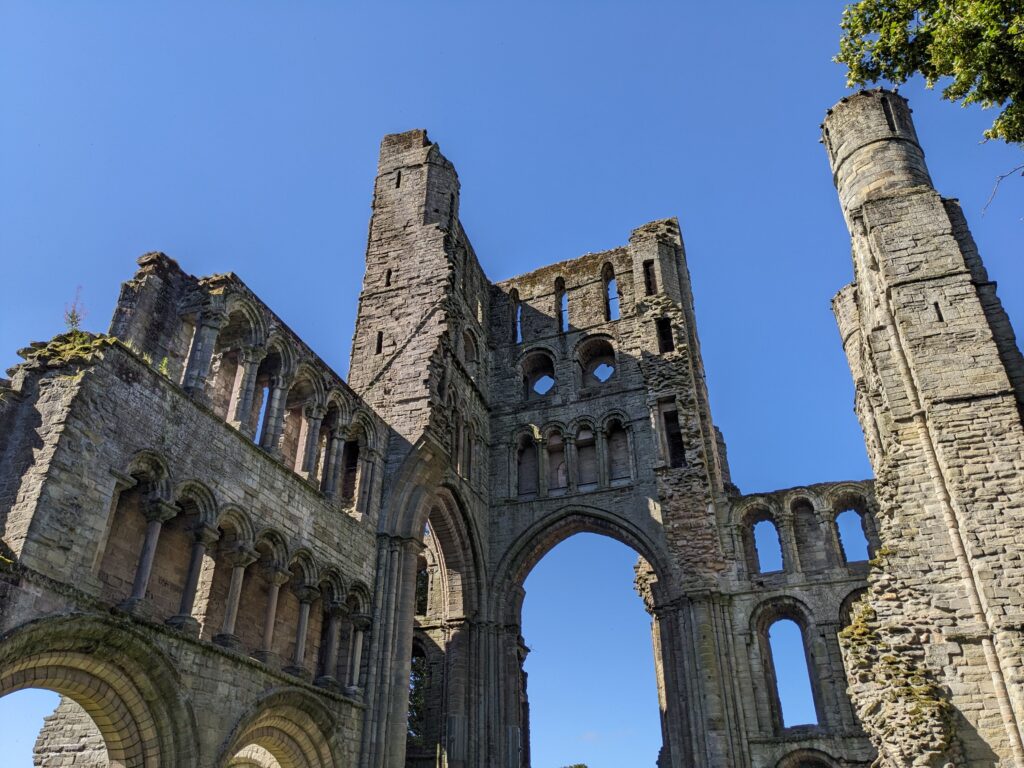 Upward view of ruined abbey, with visible archways and windows