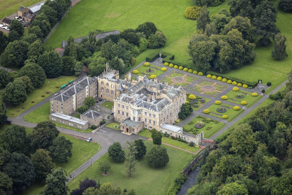 aerial view of abbey, surrounded by manicured gardens and trees