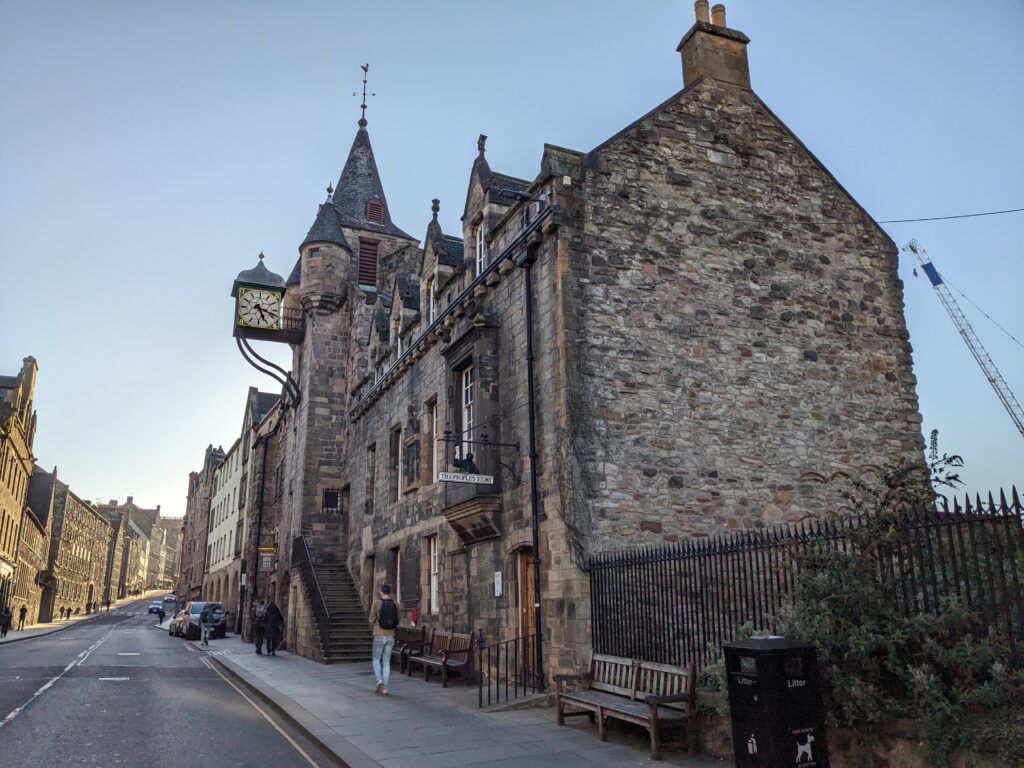View of stone building with the tolbooth tower and clock. Road to the left.