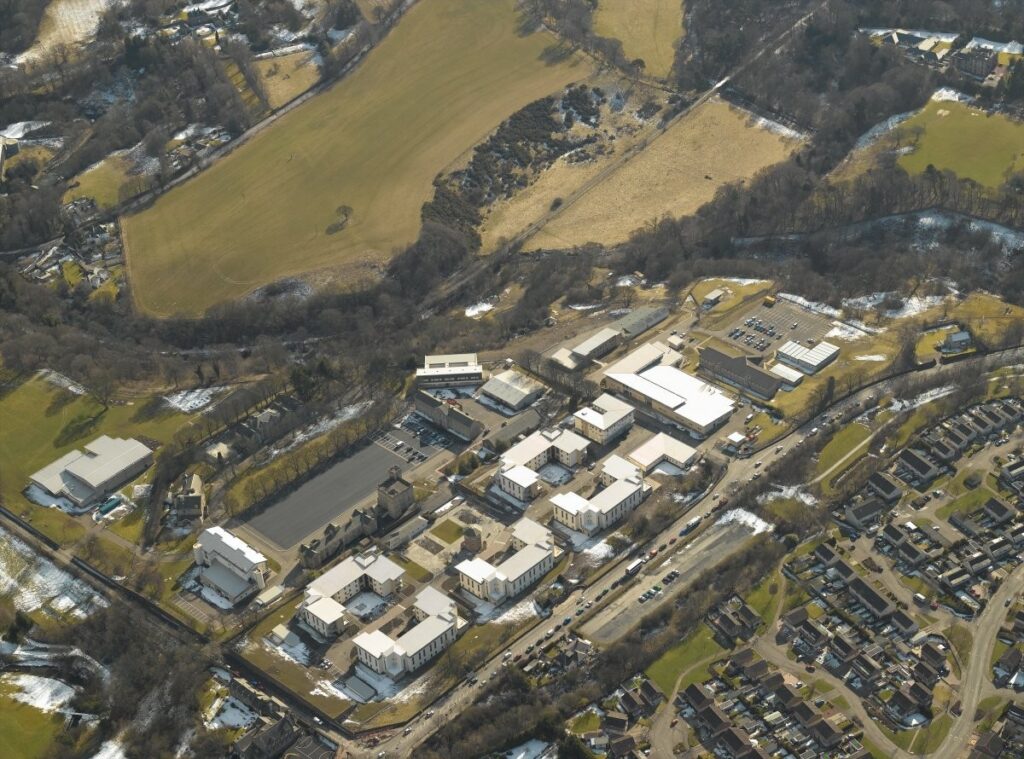 aerial view of barracks with fields to one side and settlement to the other