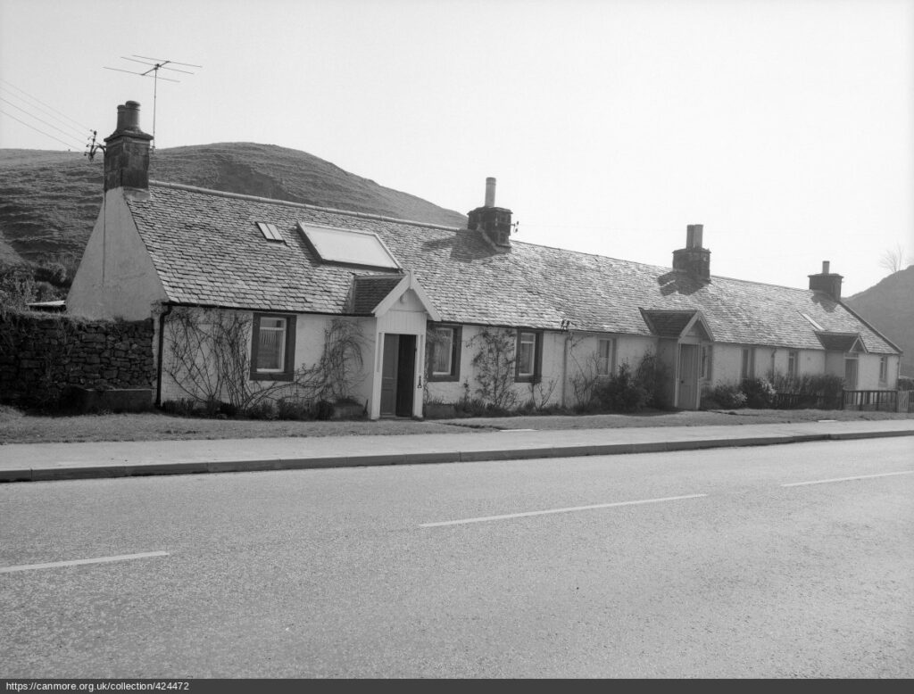 black and white photograph from street of cottages