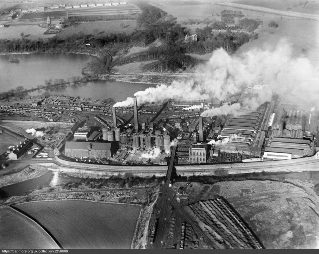 black and white aerial photograph of Carron Iron Works with steam from towers