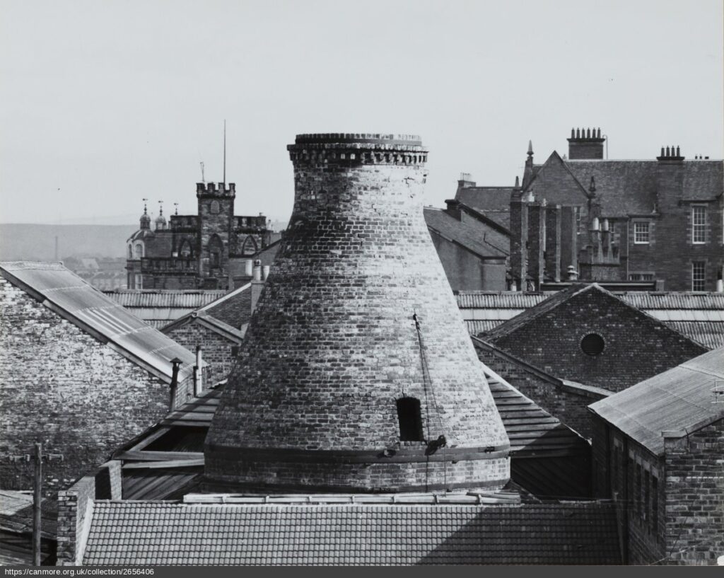 Black and white photograph of kiln cone above the roofs of houses
