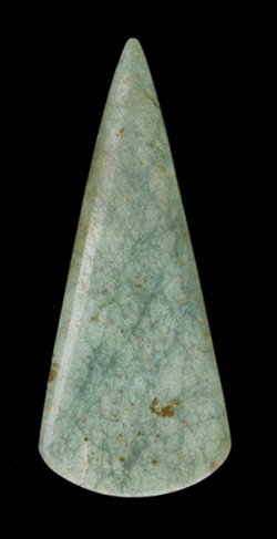 green polished axehead on black background