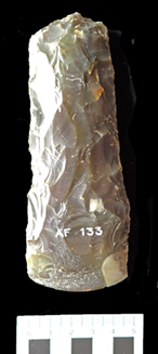 photograph of front view of axehead against black background