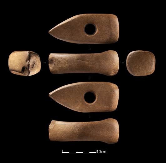 Photograph of axehead from each side and top and bottom. On a black background