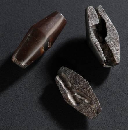photograph of two beads (in three pieces) on a black background