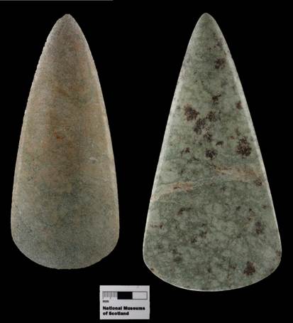Two polished stone axeheads, the left smaller than the right, on a black background