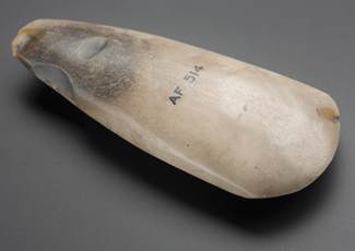 Photograph of axehead, oblique view, on grey background