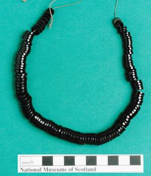 Photograph of necklace, on green background