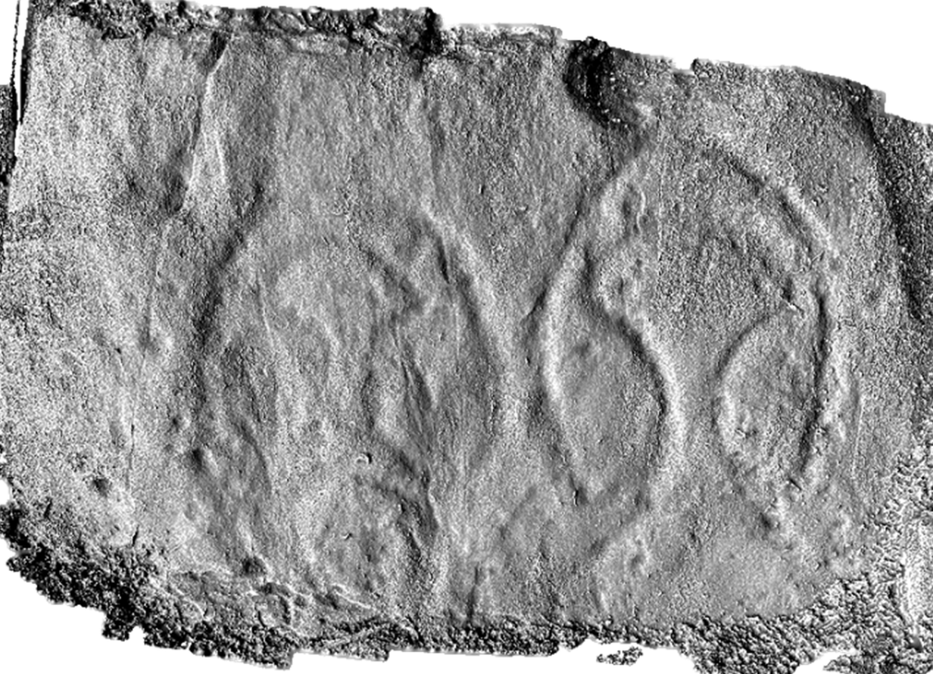 Black and white model of a carved stone with curved and angular lines resembling two axes.