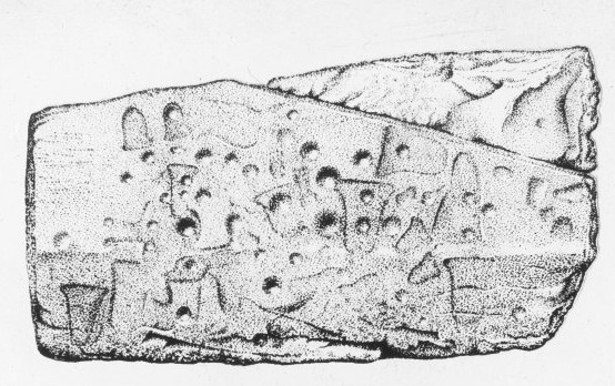 Black and white image of a sub-rectangular stone with bell-shaped carvings and cupmarks across it.