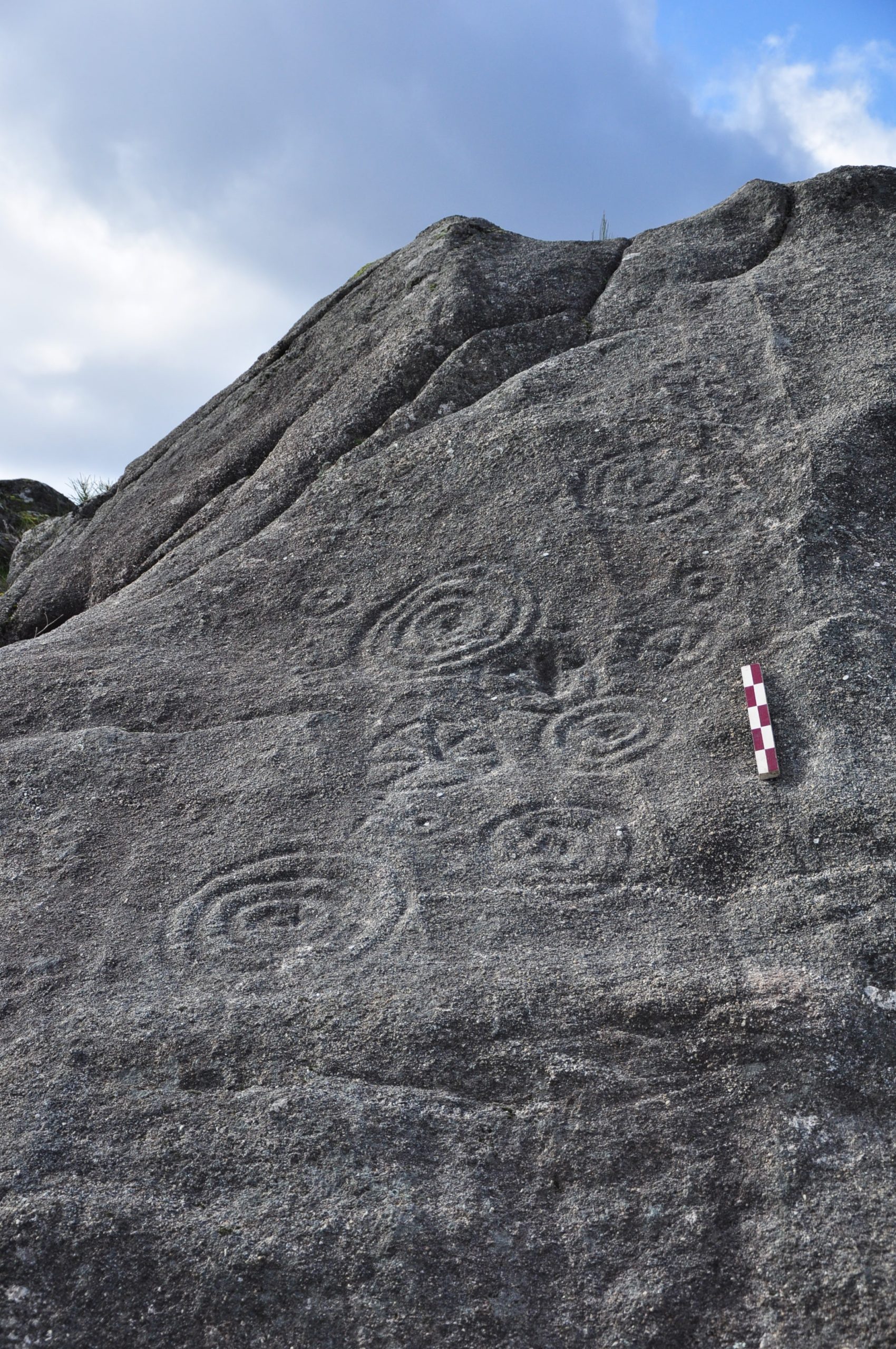 Circular carvings on the side of a steep rocky cliff