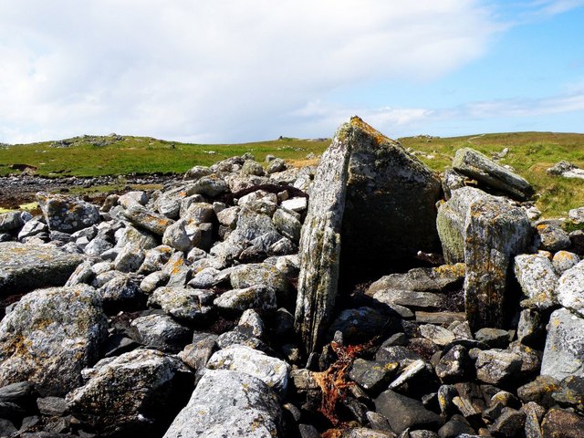A large pile of stones and boulders with upright stones protruding from the pile denoting an entrance to a tomb.