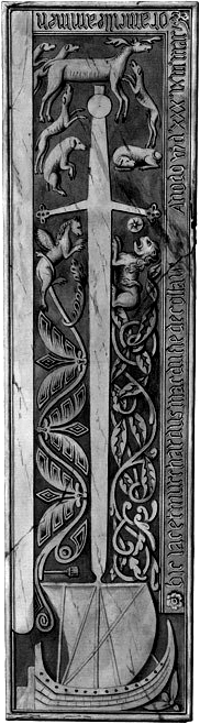 Long vertical carved stone with interlaced design, animals, scripture, and a large sail ship at the bottom of the stone. 